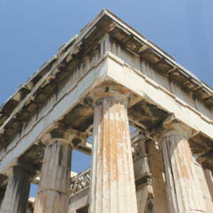 Ancient Greek temple columns under a clear blue sky.